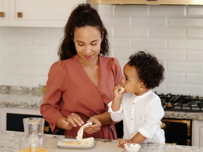 Uma mãe e seu filho, em sua rotina matinal na cozinha, representam o melhor momento do dia para a suplementação de vitamina D, geralmente feita durante o café da manhã.