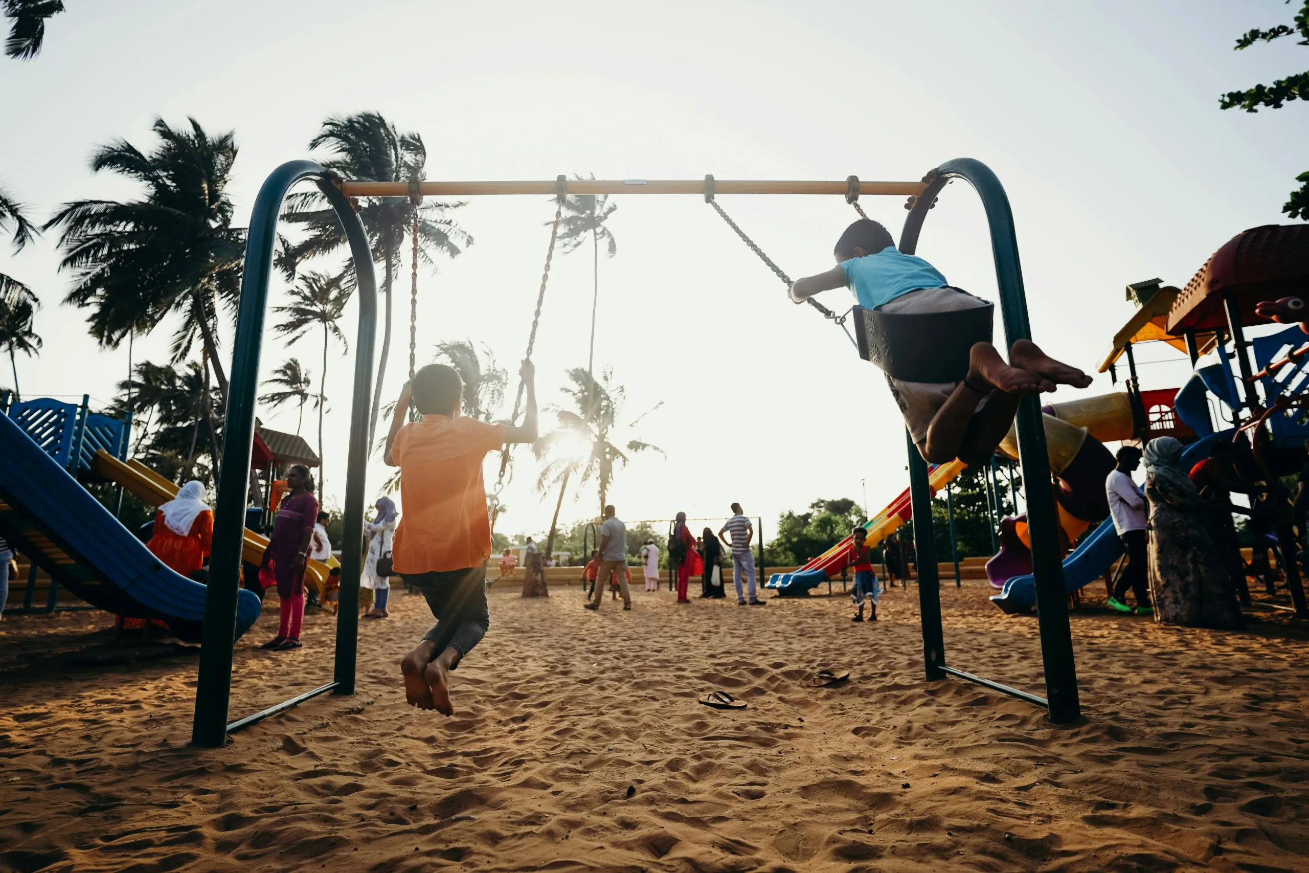 Duas crianças brincam alegremente em um balanço em um parque infantil